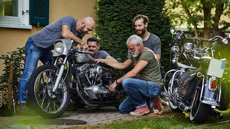 四个朋友在屋外骑摩托车